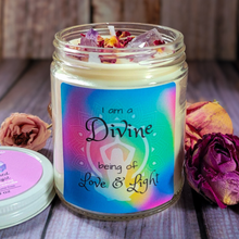 Load image into Gallery viewer, Candle jar with a colorful label reading 'I am a Divine being of Love & Light' on a wooden surface with flowers.