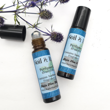 Load image into Gallery viewer, Two roll-on perfume bottles with blue labels on a white background with purple flowers.