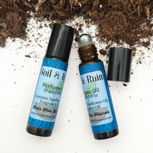 Load image into Gallery viewer, Two roll-on bottles with blue labels on a white background with soil and rocks.