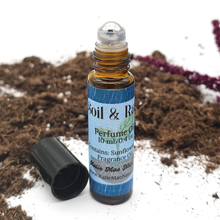 Load image into Gallery viewer, Roll-on perfume bottle labeled 'Soil & Rain' on a natural background