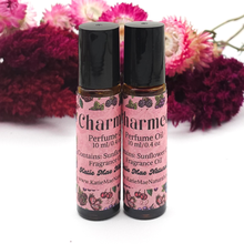 Load image into Gallery viewer, Two perfume oil bottles with pink labels against a floral background