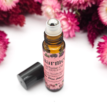 Load image into Gallery viewer, Perfume oil bottle with pink label on a white background with pink flowers