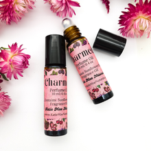 Load image into Gallery viewer, Two perfume oil bottles with pink labels on a white background with pink flowers.