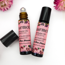 Load image into Gallery viewer, Two roll-on perfume bottles with pink labels on a white background with flowers.