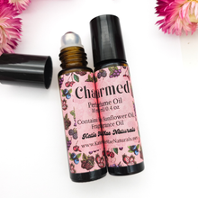 Load image into Gallery viewer, Two roller bottles of 'Charmed' perfume oil with floral designs on a white background.