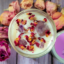 Load image into Gallery viewer, Candle in a jar with rose petals and decorative stones, surrounded by dried roses on a wooden surface.

