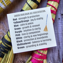 Load image into Gallery viewer, Colorful broomsticks with a card explaining color meanings on a wooden surface
