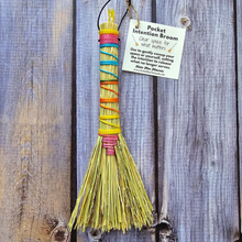 Load image into Gallery viewer, Colorful pocket intention broom with a label on a wooden background
