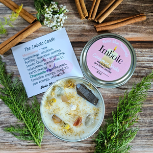 Imbolc candle scented in cinnamon sticks and decorated with crystals